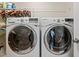 Laundry room with a front load washer and dryer and overhead shelving at 241 Serenity Hill Cir, Chapel Hill, NC 27516