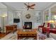 Comfortable living room with fireplace, ceiling fan, and large windows at 241 Serenity Hill Cir, Chapel Hill, NC 27516