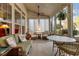 Inviting sunroom with ample windows, wicker furniture, ceiling fan, and decorative hanging plant at 241 Serenity Hill Cir, Chapel Hill, NC 27516