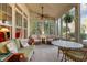 Inviting sunroom with ample windows, wicker furniture, ceiling fan, and decorative hanging plant at 241 Serenity Hill Cir, Chapel Hill, NC 27516