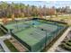 Aerial shot of fenced tennis courts, with green surface and blue accents, surrounded by trees at 241 Serenity Hill Cir, Chapel Hill, NC 27516