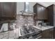 Stainless steel gas cooktop and range, granite countertops, and dark wood cabinets at 2500 Shadow Hills Ct Ct, Raleigh, NC 27612