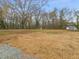Large backyard with gravel driveway and mature trees at 320B W Orange St, Hillsborough, NC 27278