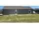 Rear view of house showcasing brown siding and small patio at 39 Harvest Hills Ln, Dunn, NC 28334