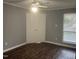 Bedroom features hardwood floors, a ceiling fan, and a window with white trim at 514 New Kent Pl, Cary, NC 27511