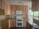 Traditional-style kitchen featuring light wood cabinets, granite countertops, and modern white appliances at 514 New Kent Pl, Cary, NC 27511