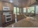 Bright kitchen with granite counters, a stainless steel sink, and view of the wooded outdoors at 514 New Kent Pl, Cary, NC 27511