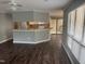 Open-concept living room featuring gray walls, hardwood floors, and a partial view of the kitchen at 514 New Kent Pl, Cary, NC 27511