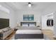 Staged bedroom with a walk-in closet, large bed, and views of the surrounding area at 615 Daniels St # 316, Raleigh, NC 27605