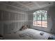 Unfinished bedroom featuring large window with natural light and a tray ceiling at 6805 Greystone Dr, Raleigh, NC 27615