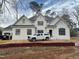 Newly constructed white brick home featuring a black roof and black trim windows at 6805 Greystone Dr, Raleigh, NC 27615