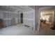 Bright, airy living room under construction with exposed framing, doorway leading to another room and sliding glass doors at 6805 Greystone Dr, Raleigh, NC 27615