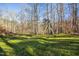 A spacious and green backyard featuring mature trees and a swing set, perfect for Gathering activities and outdoor fun at 811 Oxbow Crossing Rd, Chapel Hill, NC 27516