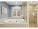 Bright bathroom featuring a large soaking tub, glass shower, and tranquil window view at 811 Oxbow Crossing Rd, Chapel Hill, NC 27516