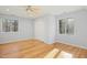 Bright bedroom featuring hardwood floors, a ceiling fan, and two windows offering natural light at 811 Oxbow Crossing Rd, Chapel Hill, NC 27516