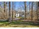 Elegant white home with manicured lawn is nestled among trees, offering serene privacy at 811 Oxbow Crossing Rd, Chapel Hill, NC 27516