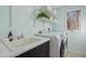 Bright laundry room features a utility sink, shelving, washer, and dryer at 811 Oxbow Crossing Rd, Chapel Hill, NC 27516