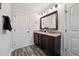Bathroom with dark-stained double vanity, granite countertops, and modern lighting at 320 Westgrove Ct, Durham, NC 27703