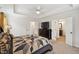 Bright bedroom features neutral walls, tray ceiling, ceiling fan, and doorway to bathroom at 320 Westgrove Ct, Durham, NC 27703