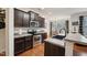 Well-lit kitchen with stainless steel appliances, dark cabinets and wood flooring at 320 Westgrove Ct, Durham, NC 27703