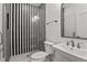 Stylish bathroom featuring a unique striped glass shower, a pedestal sink and framed mirror at 3304 Cheswick Dr, Raleigh, NC 27609