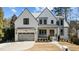 Beautiful white brick home featuring a three-car garage and meticulously landscaped front yard at 3304 Cheswick Dr, Raleigh, NC 27609
