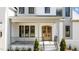 Covered front porch with brick columns, wood door, and iron railing at 3304 Cheswick Dr, Raleigh, NC 27609