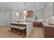 Bright kitchen features a large island with seating, modern appliances, two pendant lights and wood flooring at 3304 Cheswick Dr, Raleigh, NC 27609