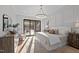 Sunlit main bedroom featuring a sliding glass door to a balcony, modern lighting, and neutral decor at 3304 Cheswick Dr, Raleigh, NC 27609