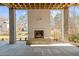 Outdoor living area with a fireplace, stone floors, and views of the backyard and surrounding trees at 3304 Cheswick Dr, Raleigh, NC 27609