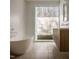 Bathroom featuring a soaking tub, double vanity, and window overlooking the yard at 6358 Pathway Ct Ct, Chapel Hill, NC 27516