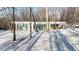 Contemporary single-story home with a flat roof design in a secluded wooded setting with snow at 6358 Pathway Ct Ct, Chapel Hill, NC 27516
