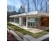 Modern home exterior with floor-to-ceiling windows, minimalist landscaping, and a flat roof design at 6358 Pathway Ct Ct, Chapel Hill, NC 27516