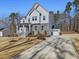 Two-story home with gray siding, stone accents, and a three-car garage at 678 The Parks Dr, Pittsboro, NC 27312