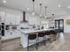 Open concept kitchen with island, white cabinets, and hardwood floors at 678 The Parks Dr, Pittsboro, NC 27312