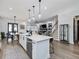 Open concept kitchen with island, white cabinets, and hardwood floors at 678 The Parks Dr, Pittsboro, NC 27312