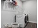 Laundry room with washer, dryer, shelving, and a gray tile floor at 678 The Parks Dr, Pittsboro, NC 27312