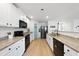Modern kitchen with granite countertops, white cabinets, and stainless steel appliances at 70 Kinsale Ct, Fuquay Varina, NC 27526