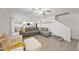 Bright living room with grey sectional sofa, wood floors and kitchen view at 70 Kinsale Ct, Fuquay Varina, NC 27526