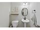 Small powder room with pedestal sink, toilet, and simple decor at 70 Kinsale Ct, Fuquay Varina, NC 27526