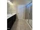 Bright bathroom featuring a double sink vanity, glass shower, and neutral color scheme at 7205 Ladbrooke St, Raleigh, NC 27617