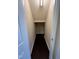 Narrow hallway with neutral walls and dark floors leads deeper into the home at 7205 Ladbrooke St, Raleigh, NC 27617