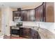 Modern kitchen with stainless steel appliances, dark cabinetry, and granite countertops at 7205 Ladbrooke St, Raleigh, NC 27617