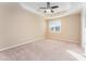 Spacious main bedroom with plush carpeting, ceiling fan, and a bright window at 7205 Ladbrooke St, Raleigh, NC 27617