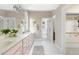 Bright bathroom with double sinks, white tile floor, and access to tub and walk-in closet at 76527 Rice, Chapel Hill, NC 27517