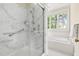 Bathroom featuring glass shower with marble surround and separate soaking tub next to window at 76527 Rice, Chapel Hill, NC 27517