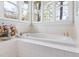 Bright bathroom featuring a large, tiled tub beneath windows offering a scenic outdoor view at 76527 Rice, Chapel Hill, NC 27517
