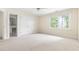 Light-filled bedroom with neutral carpet, ceiling fan, and large window overlooking greenery at 76527 Rice, Chapel Hill, NC 27517