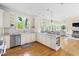 Open kitchen and living area with sleek granite countertops, white cabinets, and stainless appliances at 76527 Rice, Chapel Hill, NC 27517