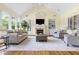 Spacious living room with a vaulted ceiling, fireplace, and oversized windows showcasing the backyard at 76527 Rice, Chapel Hill, NC 27517